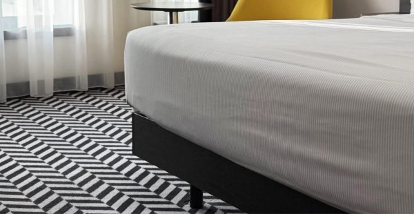 Modern eingerichteter Raum mit hochwertigem Bodenbelag und Bett, Malerbetrieb Maier-Quantius