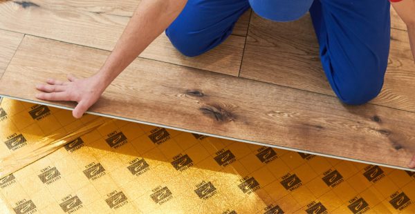 Handwerker bei der Verlegung von hochwertigem Bodenbelag in Holzoptik, Malerbetrieb Maier-Quantius